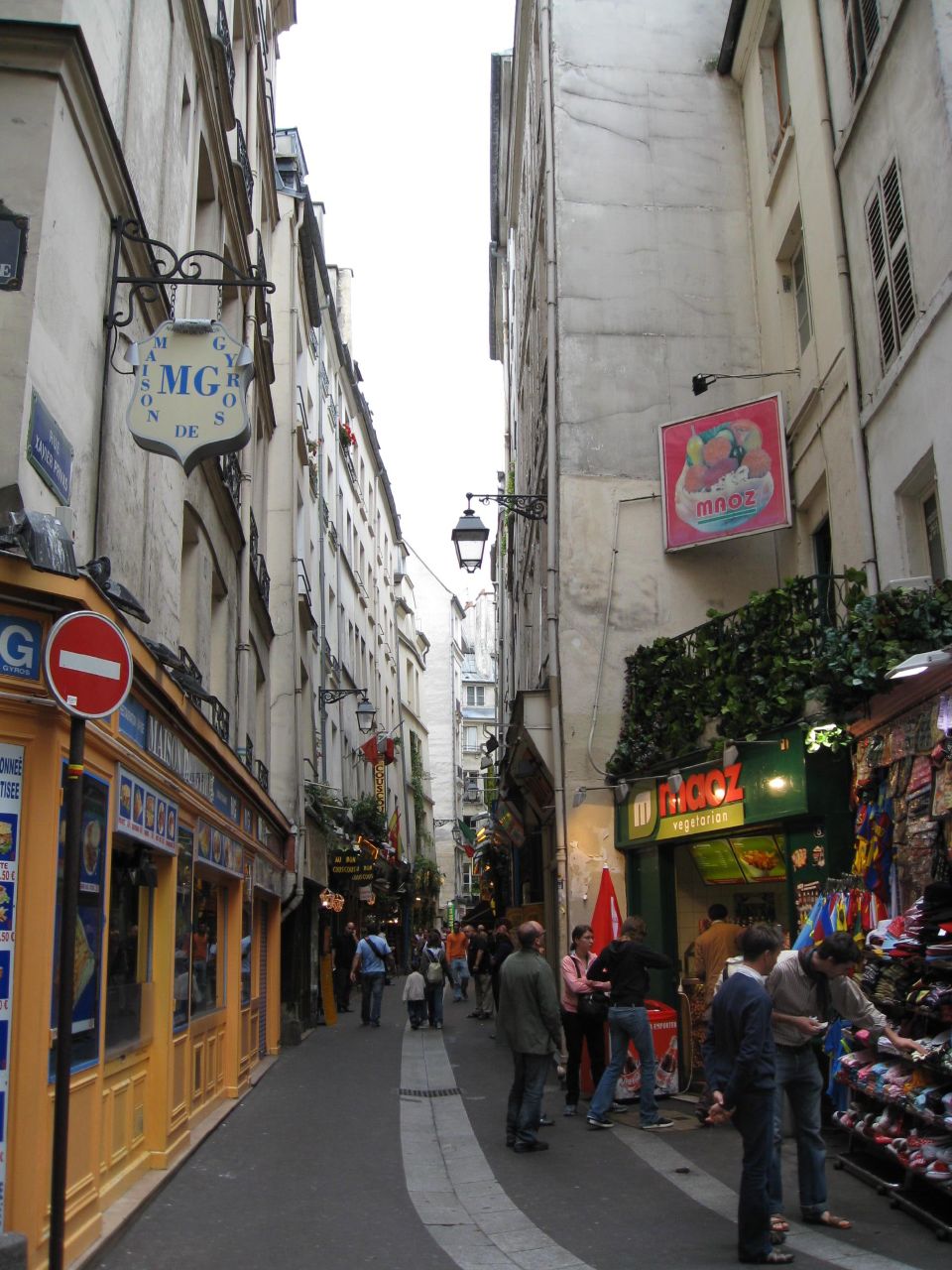 a narrow street with various shops in front