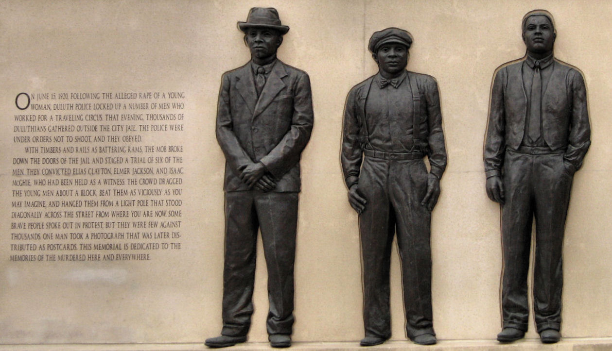 three statues are posed in front of a wall with writing
