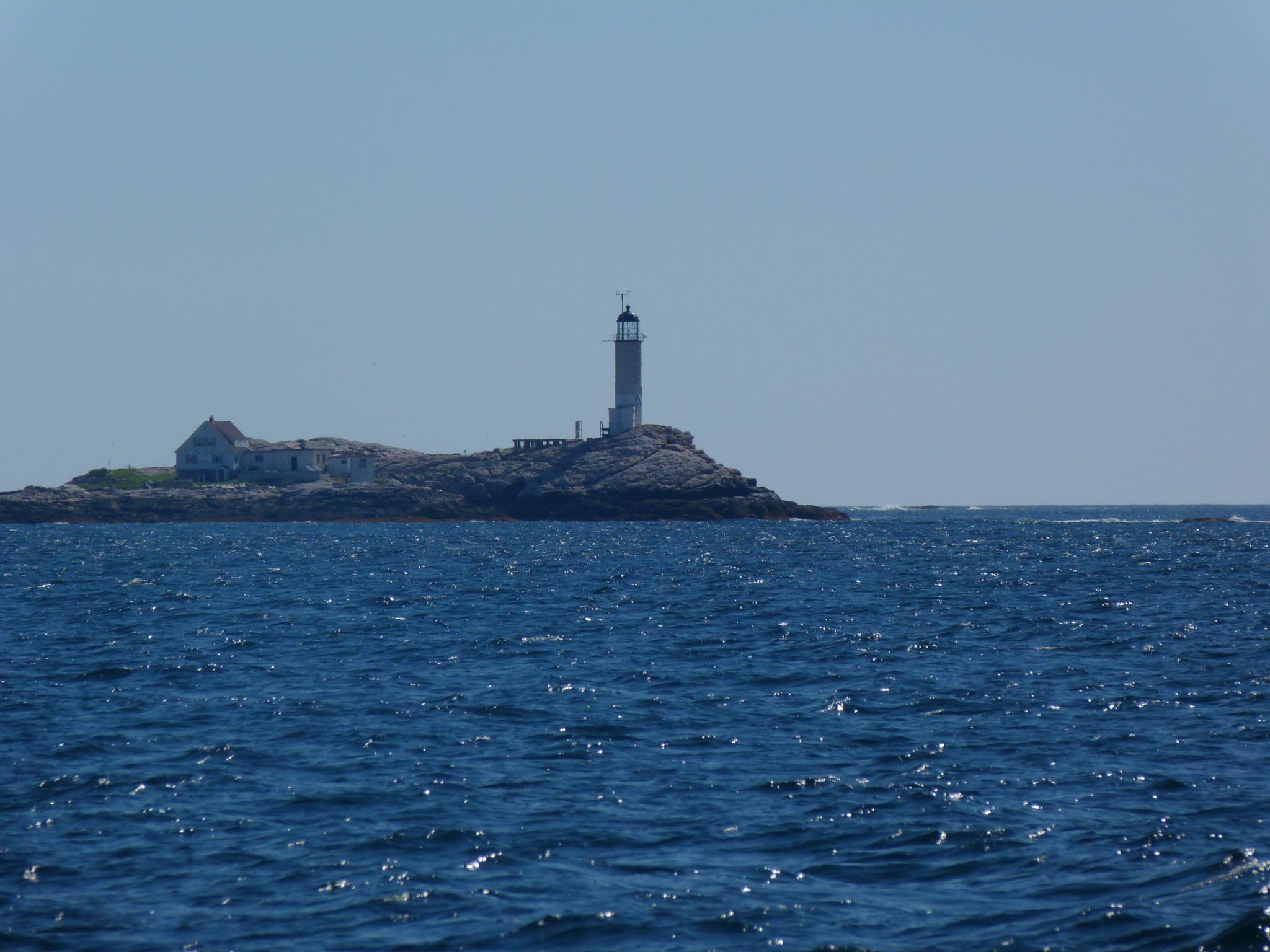 an island with a lighthouse in the middle of the ocean