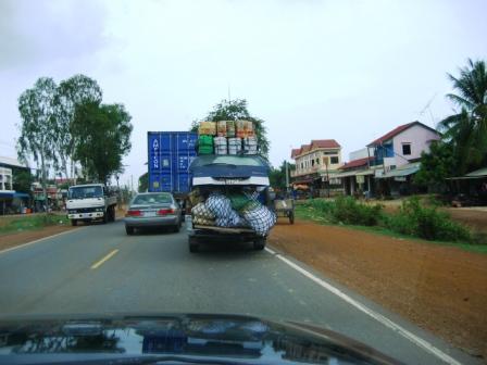 cars with luggage on top of them traveling down a busy street