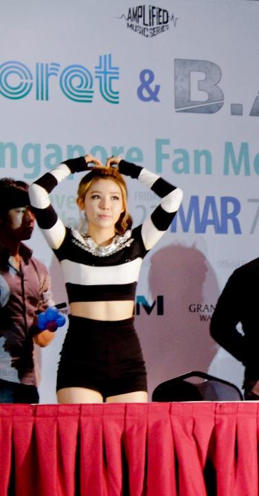 a woman in a striped top standing on stage at a music festival