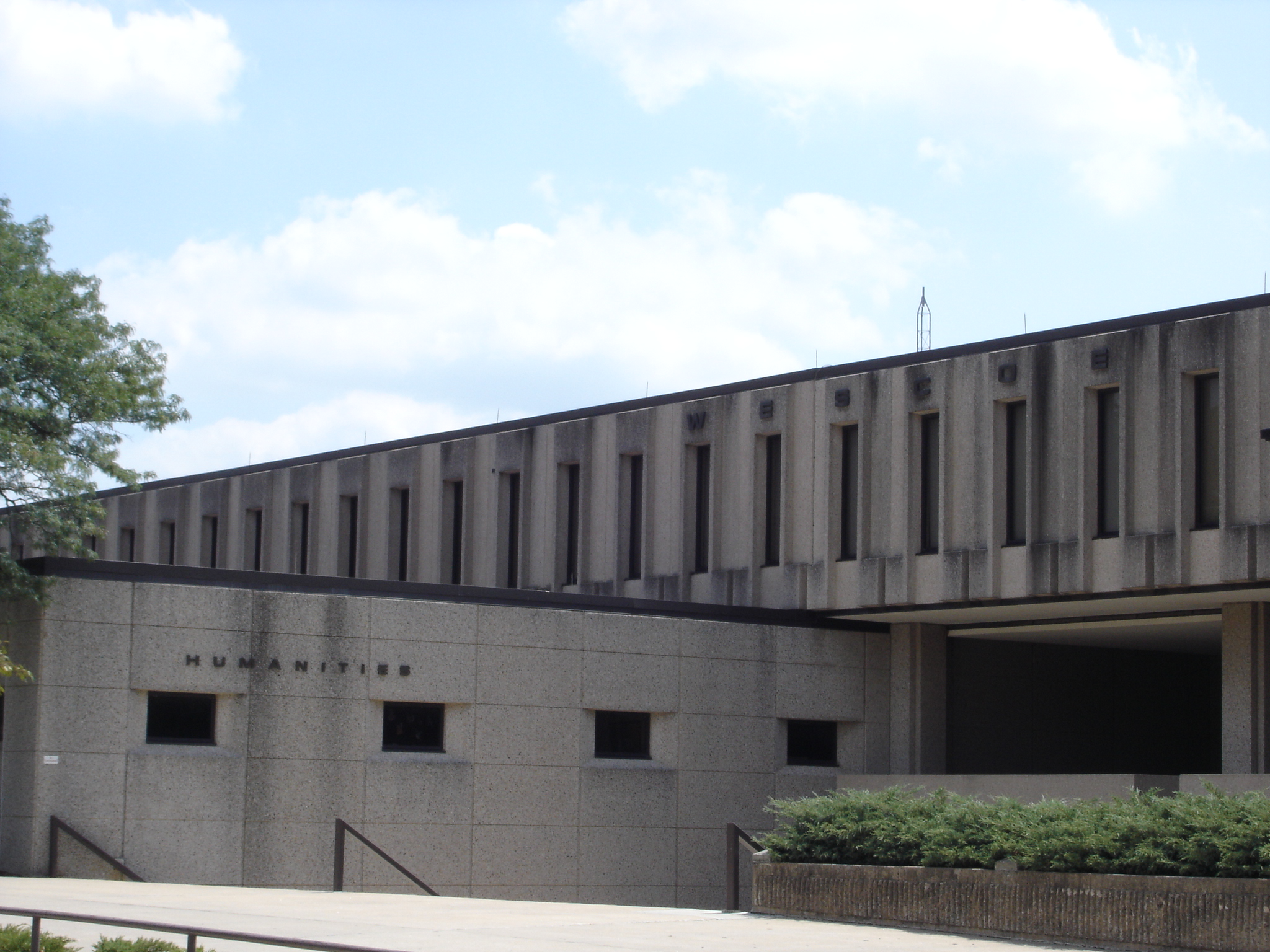 a modern building made of concrete that has a clock in it