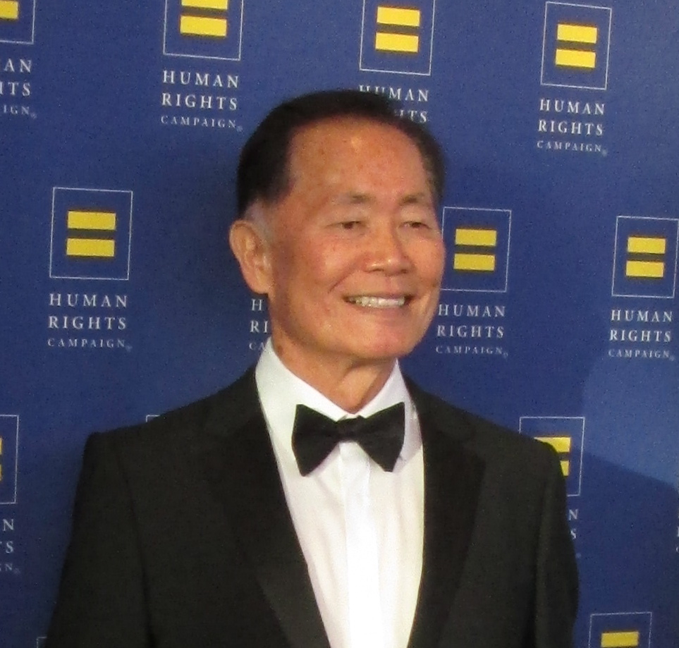 a man in a tuxedo is smiling at the camera