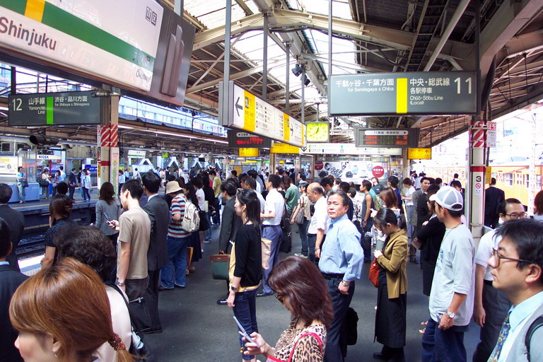 people are lined up at a train station