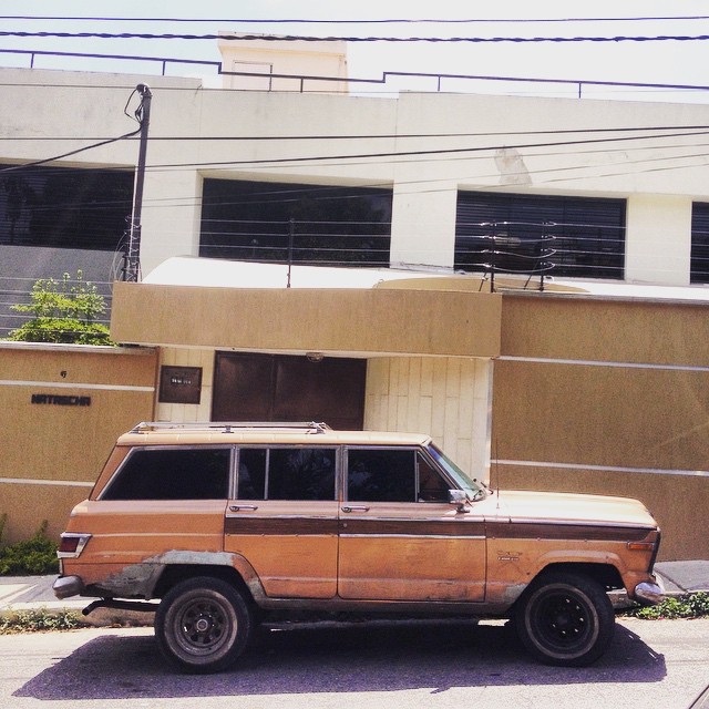 an old station wagon sits parked in front of a building