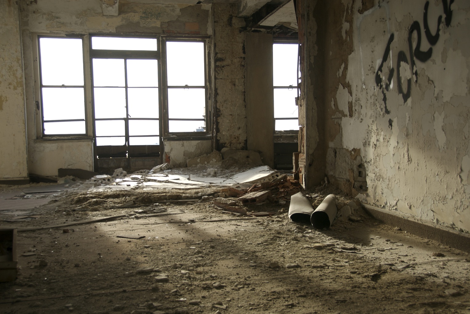 a room with windows in it, some peeling paint