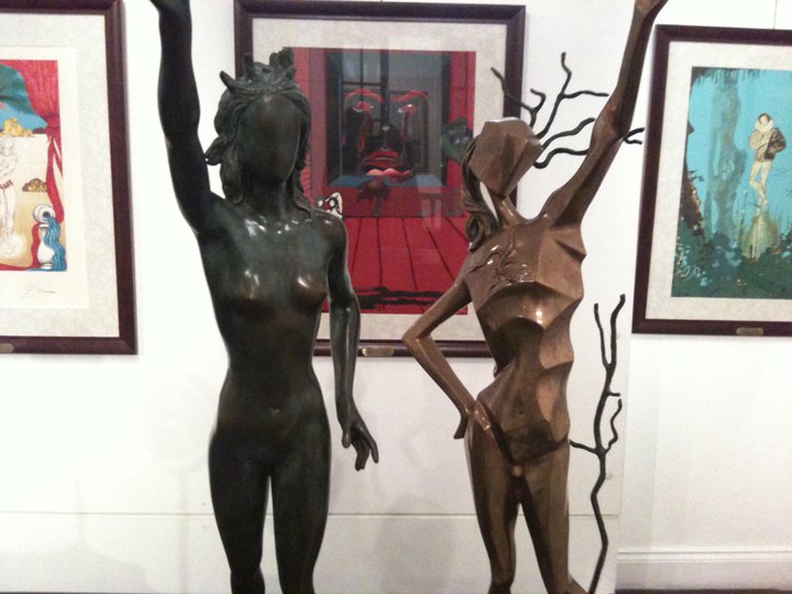 two brown statues are posed next to each other