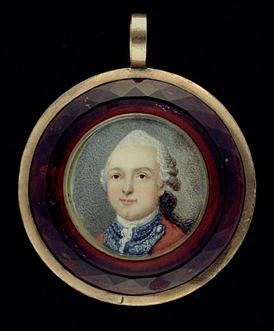 a portrait pendant with an oval frame with an image of a person