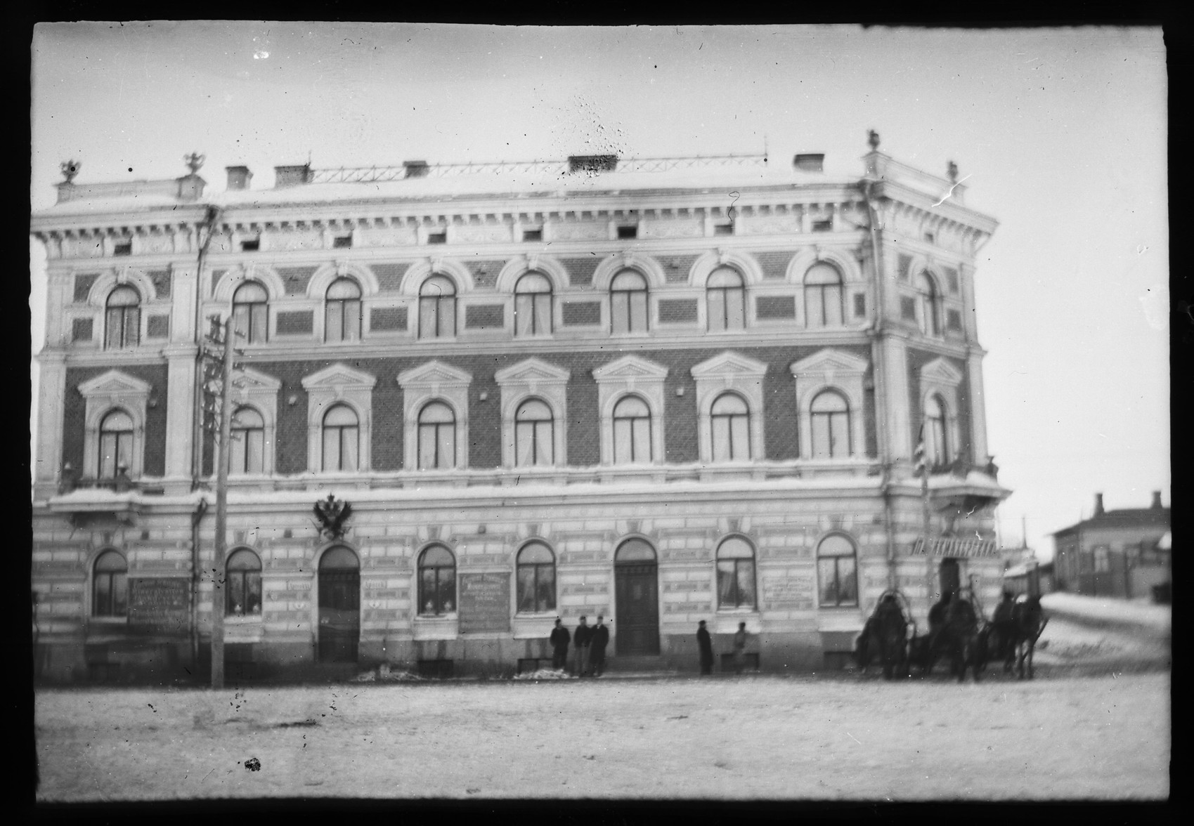 some people and horses standing in front of a building