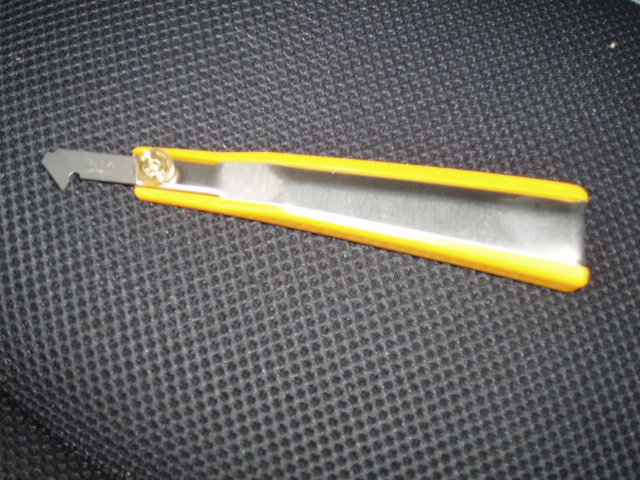 a sharp scissor with yellow handles sitting on a black cloth