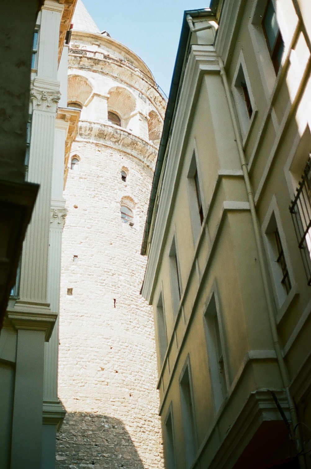 a tall brick tower stands between two other tall buildings