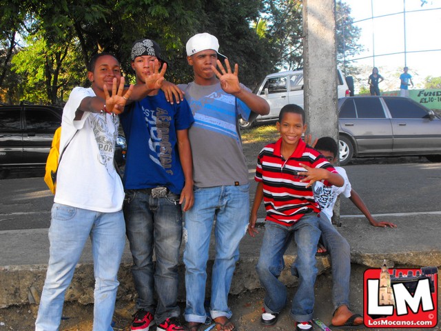 a group of young men are posing on the corner of a street