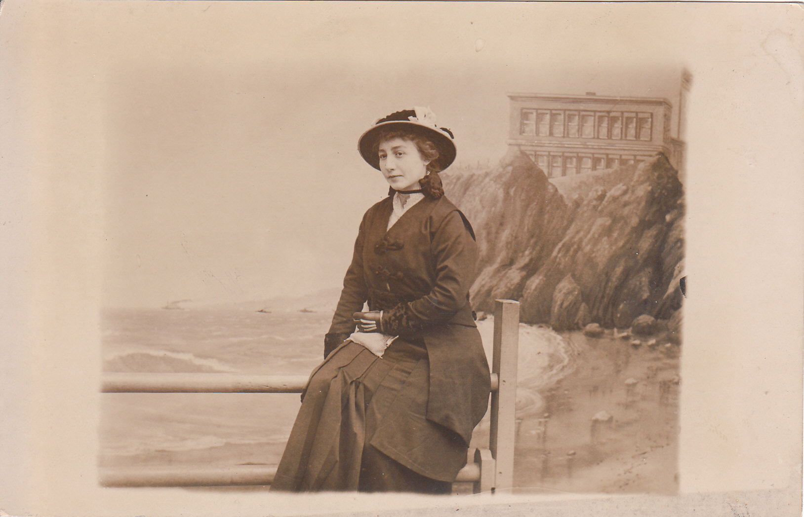 old po of woman sitting on a ledge overlooking water
