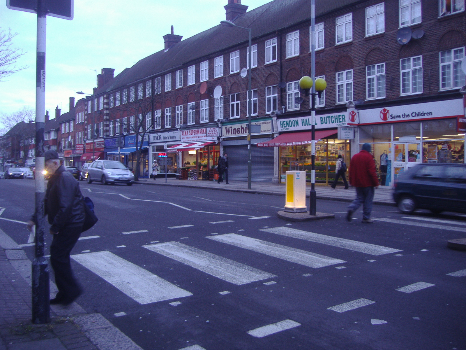 several people on the sidewalk of a city street