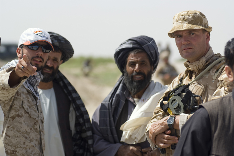 a few men are wearing various military uniforms and holding a camera