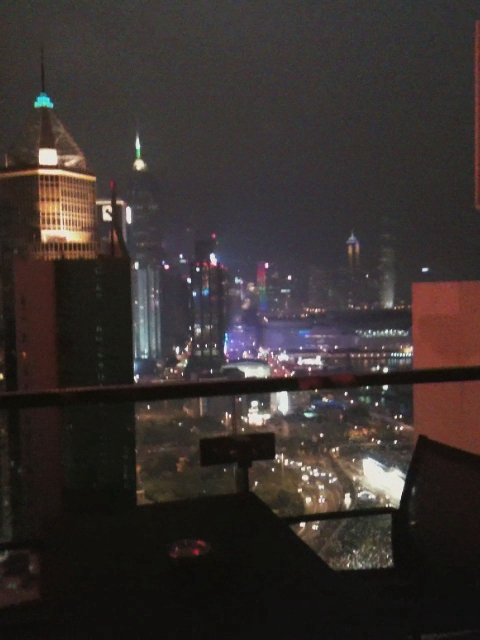 an outdoor table overlooks the city lights at night