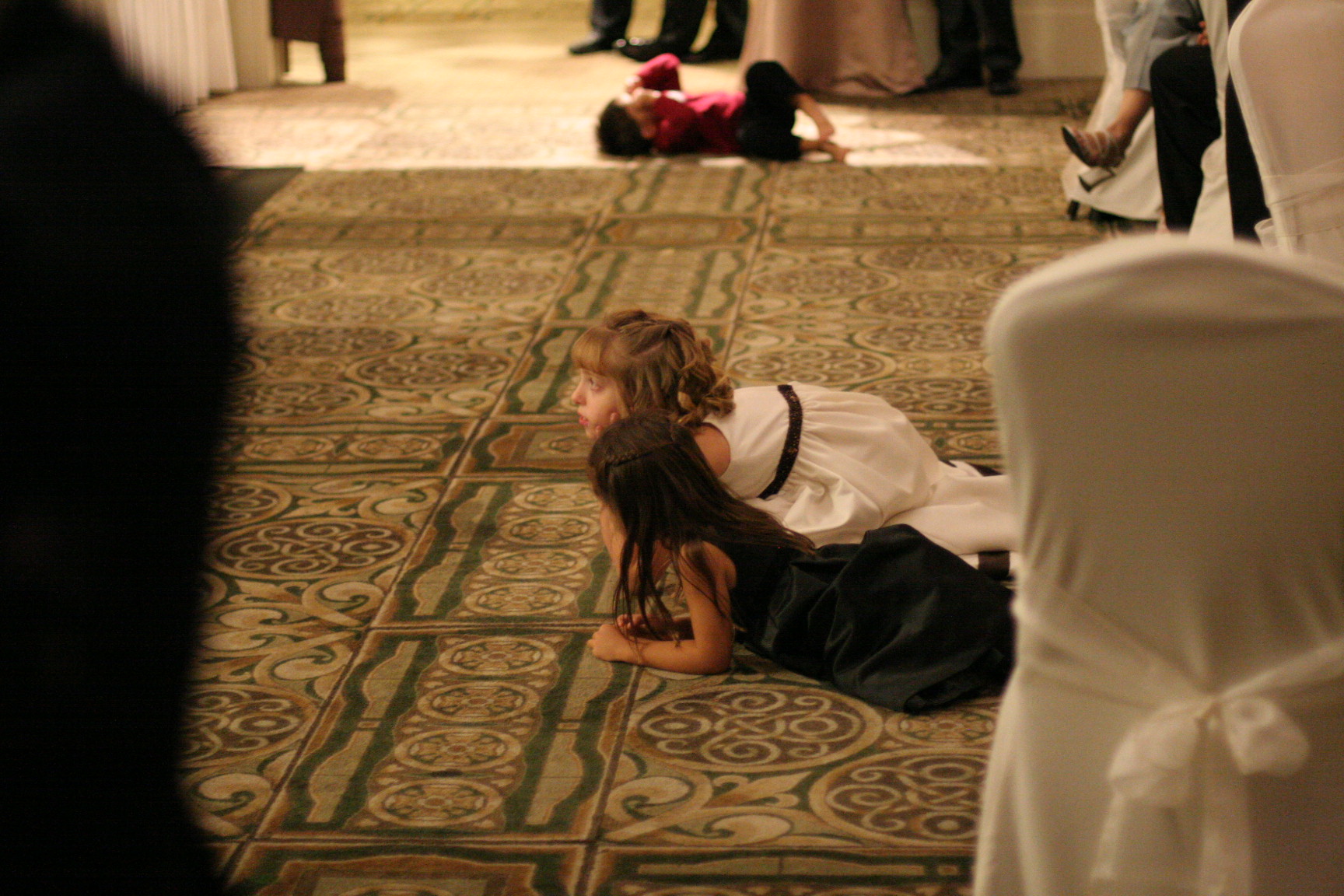 a girl in a white shirt sitting on a rug in the middle of a room