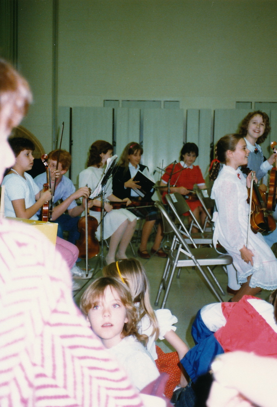 several people in white shirts and some are playing instruments