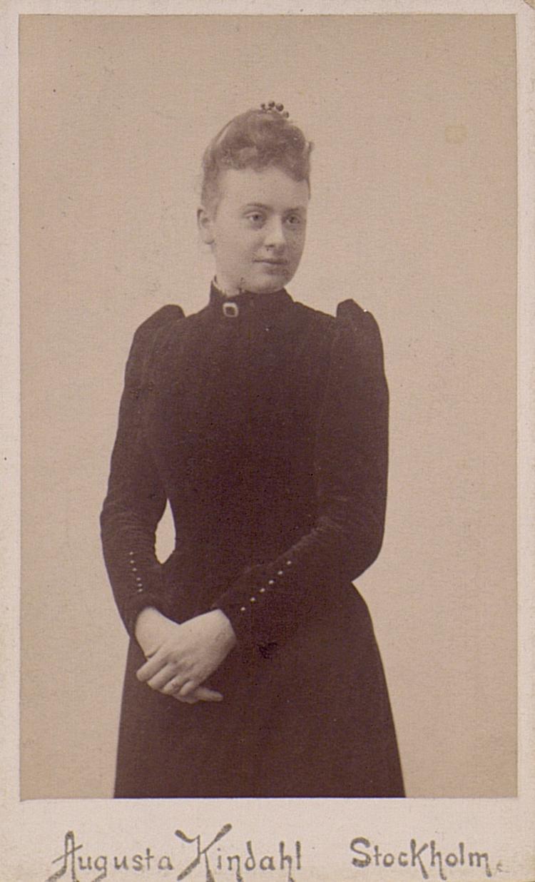 an antique pograph of a young lady wearing a black dress