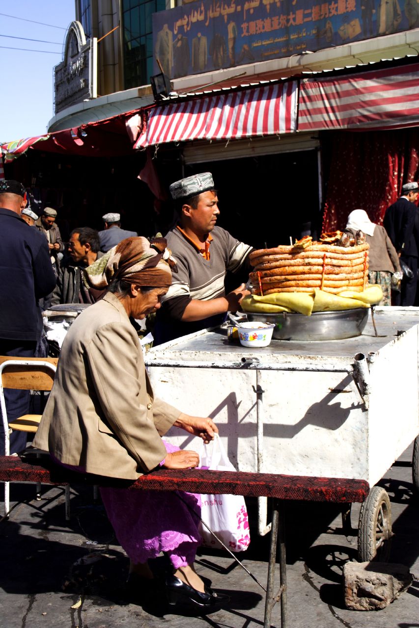 a woman serving food from a street vendor's cart
