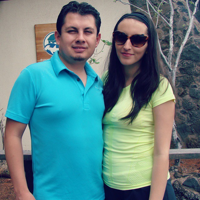 a man and woman posing in front of a house