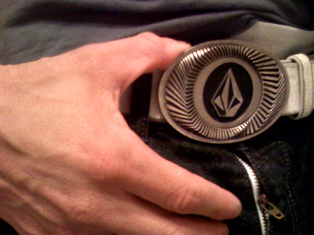 a person wearing a belt with an insignia on it