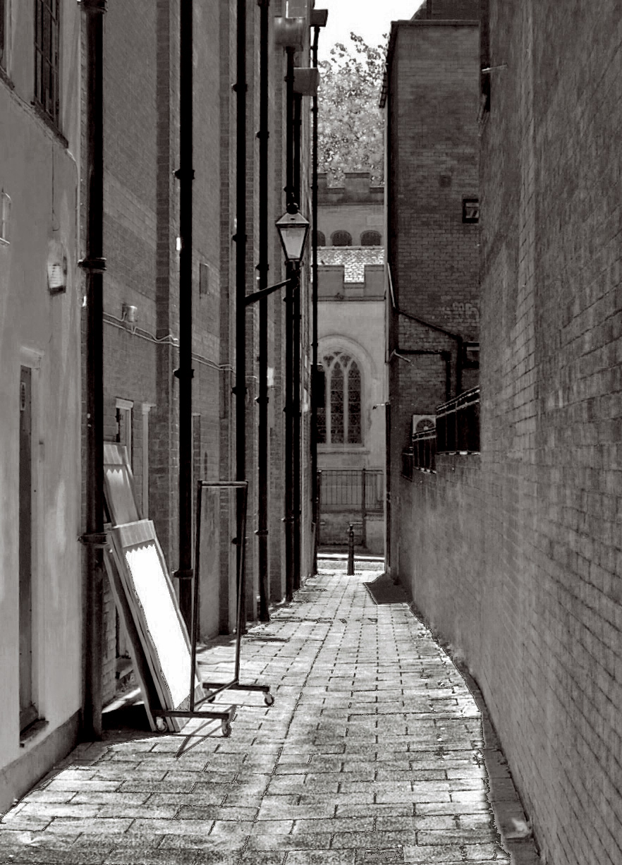 a black and white image of brick alleyway