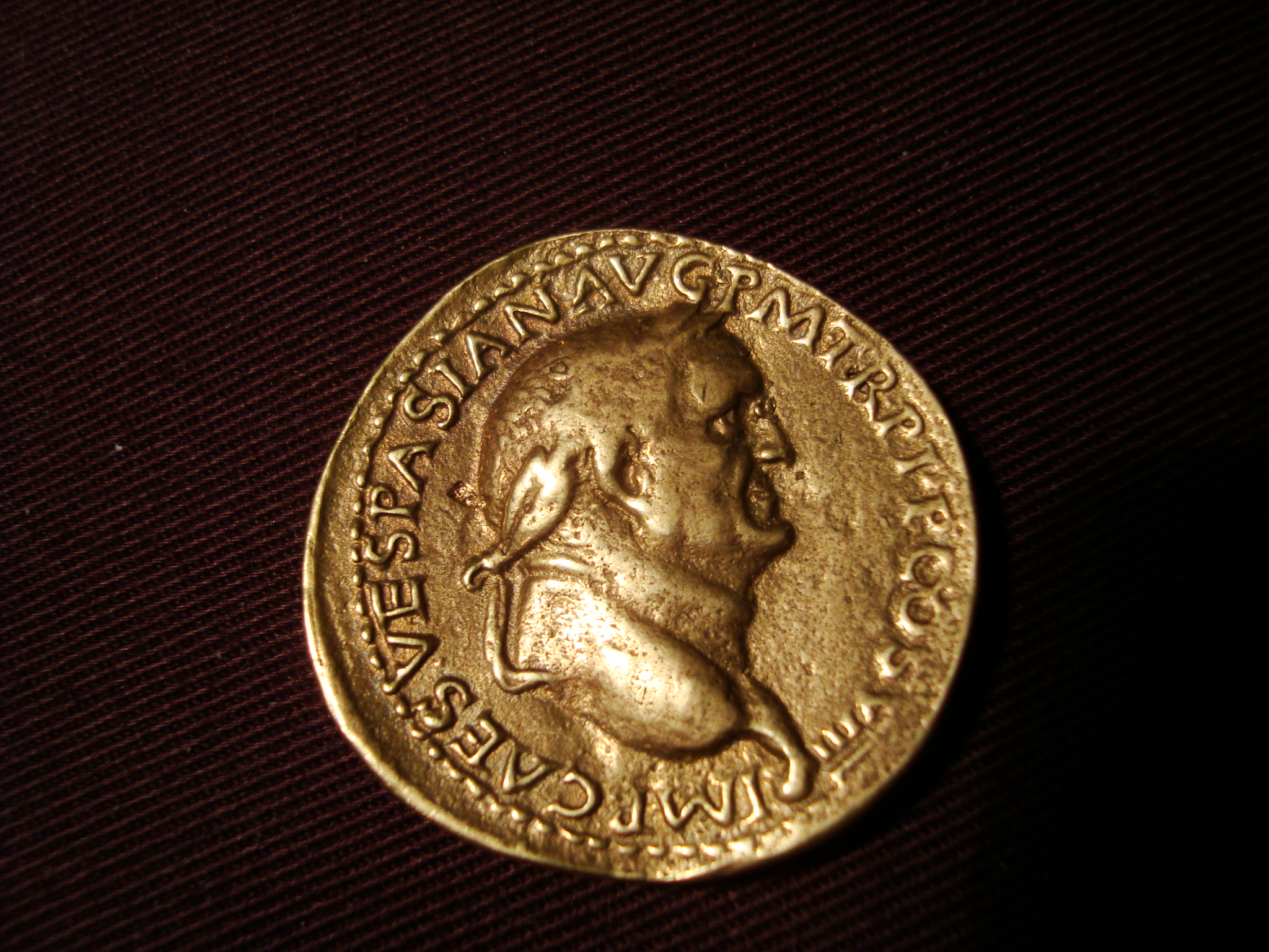 a roman gold coin from the time of her age, depicting the bust of a man in profile