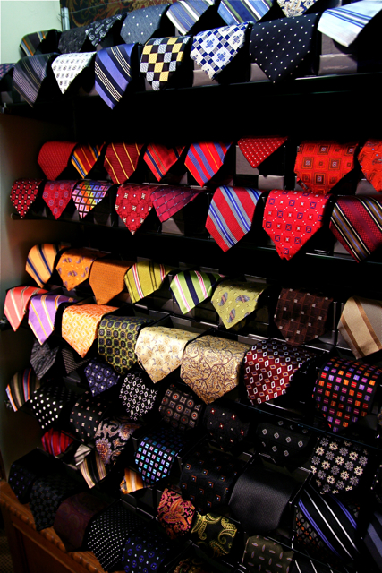 rows of tie racks with ties of different colors