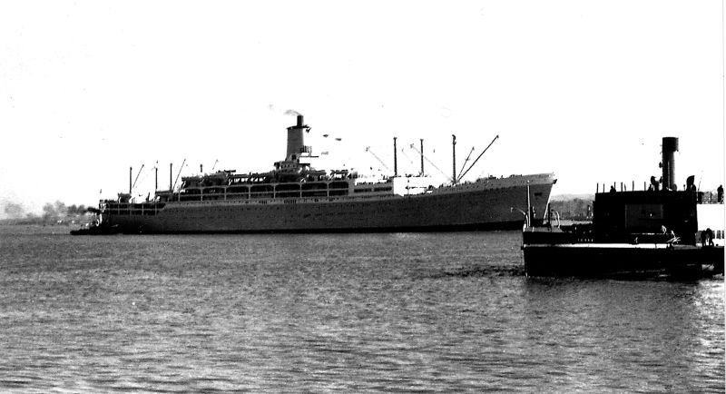 large ship and tug boat out at sea in black and white