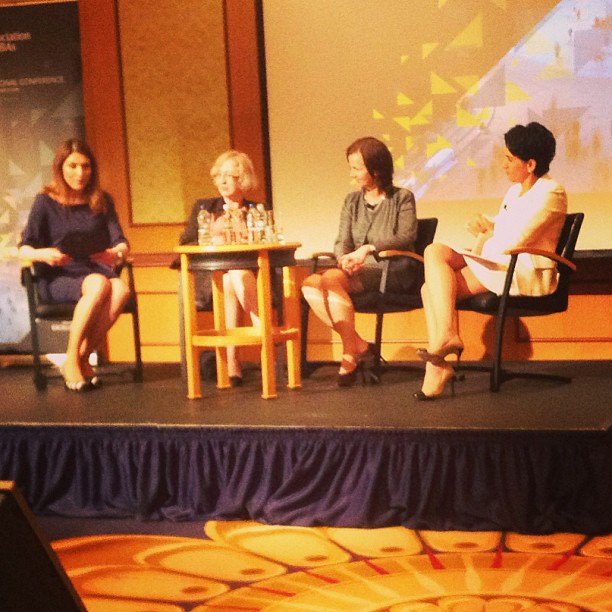 three women in a panel discussion sitting on stage