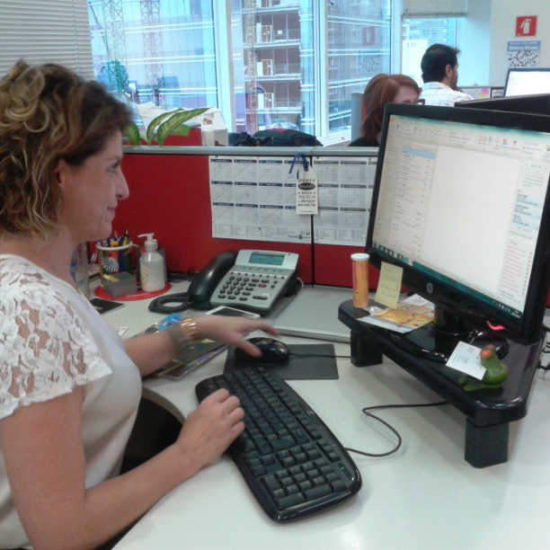 a woman using a computer and her cell phone