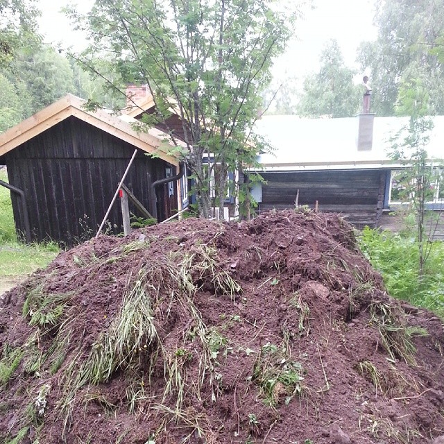 the pile of grass is sitting in front of the barn