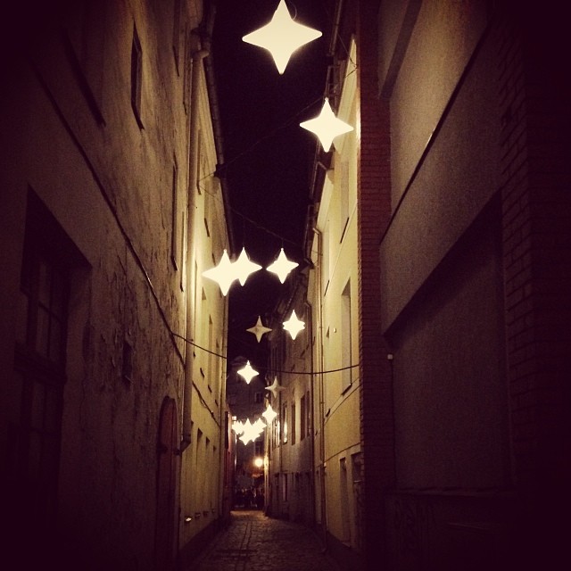 stars are hung from a string in an alley way