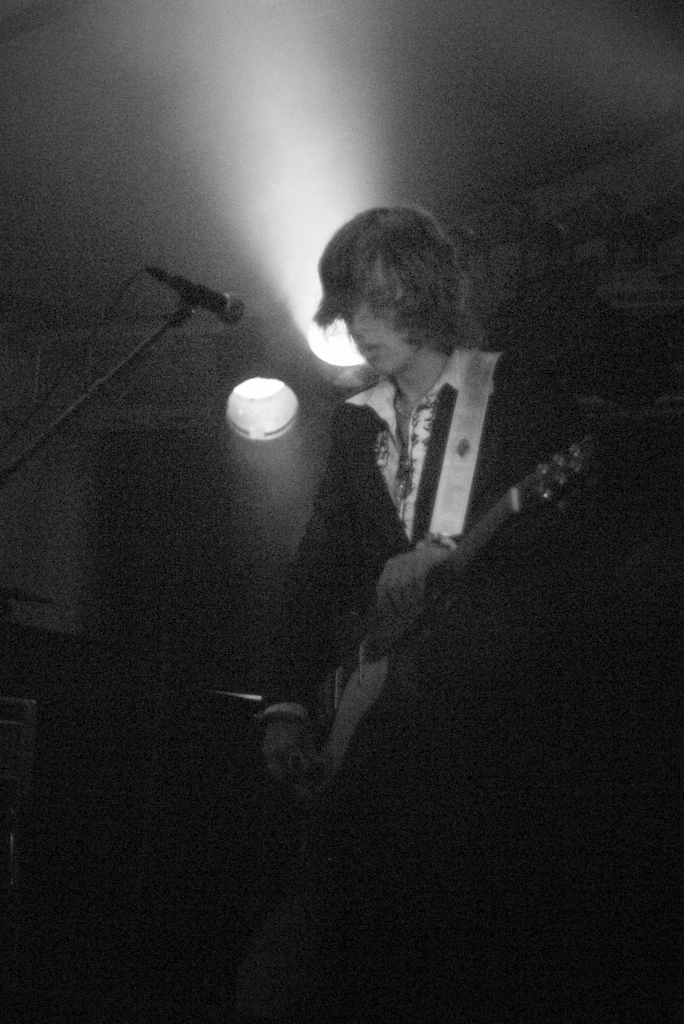 a man playing guitar in a dimly lit room