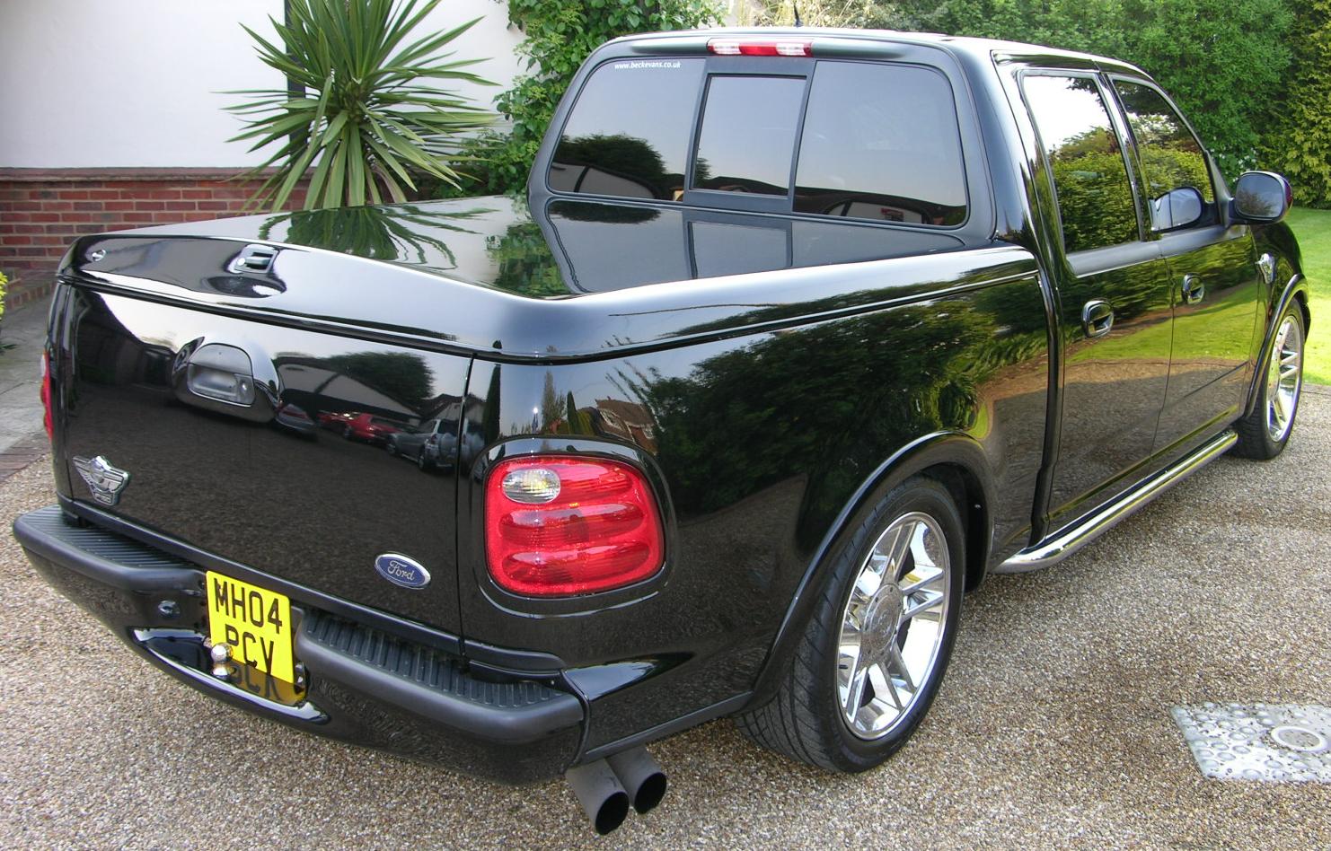 a black pickup truck is parked in a parking lot