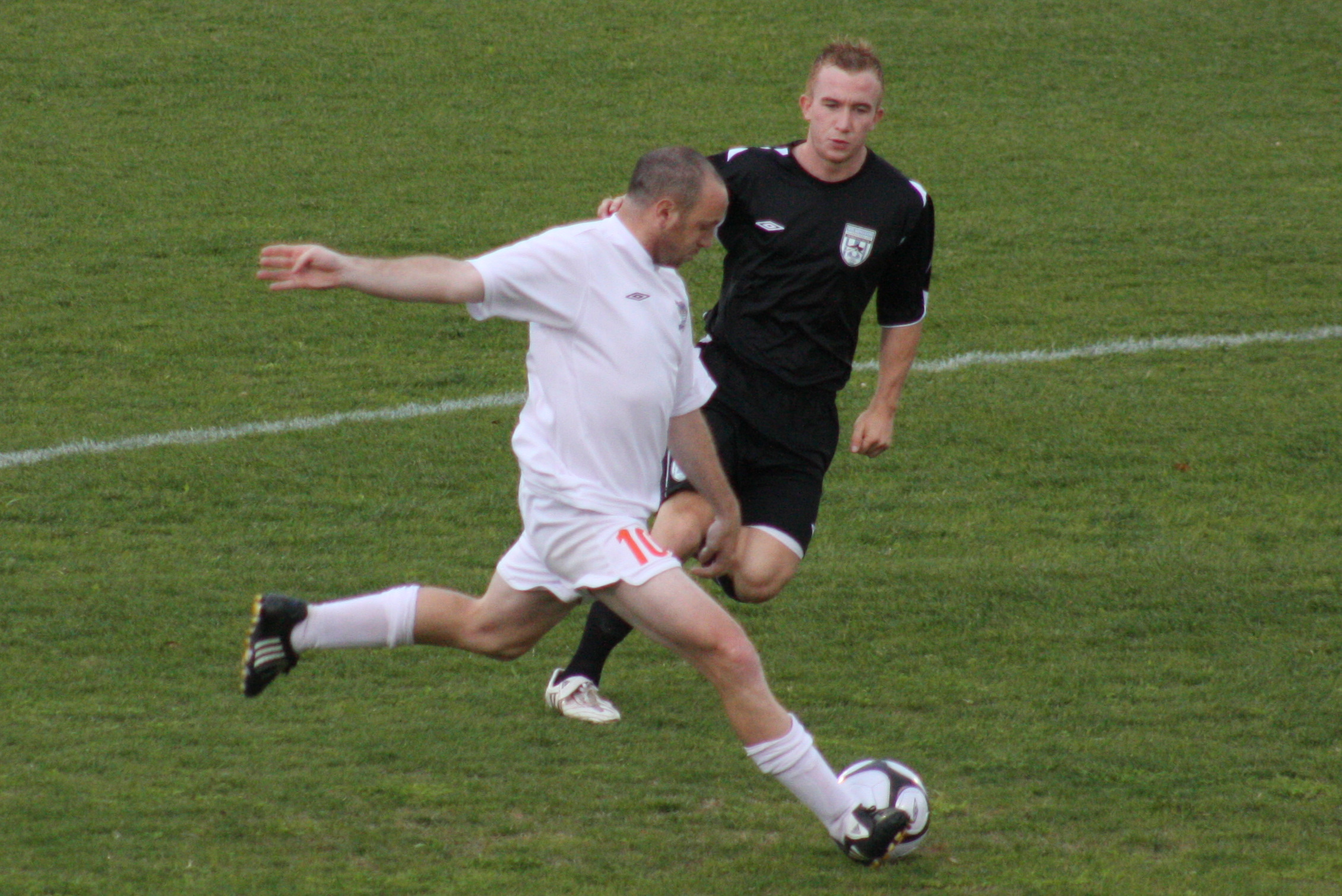 two men are playing soccer on a field