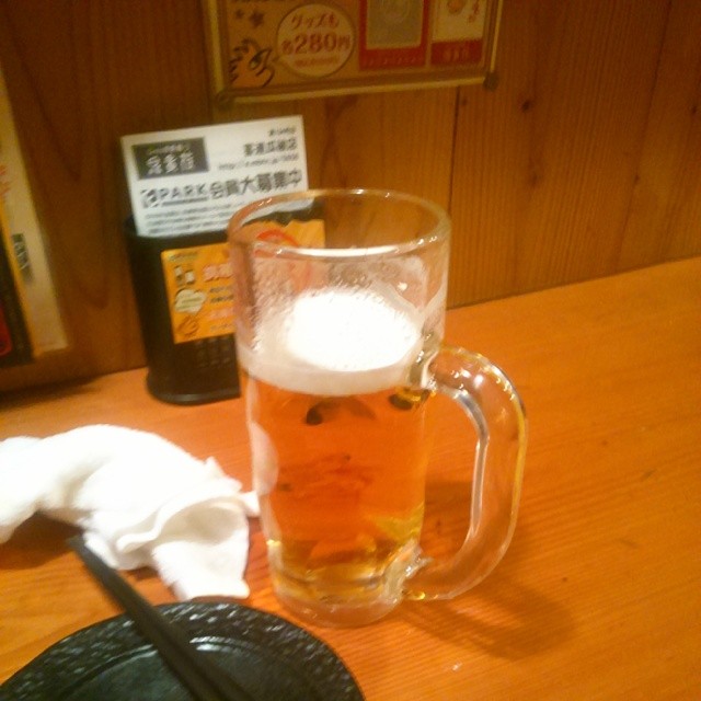 glass beer is next to a black plate