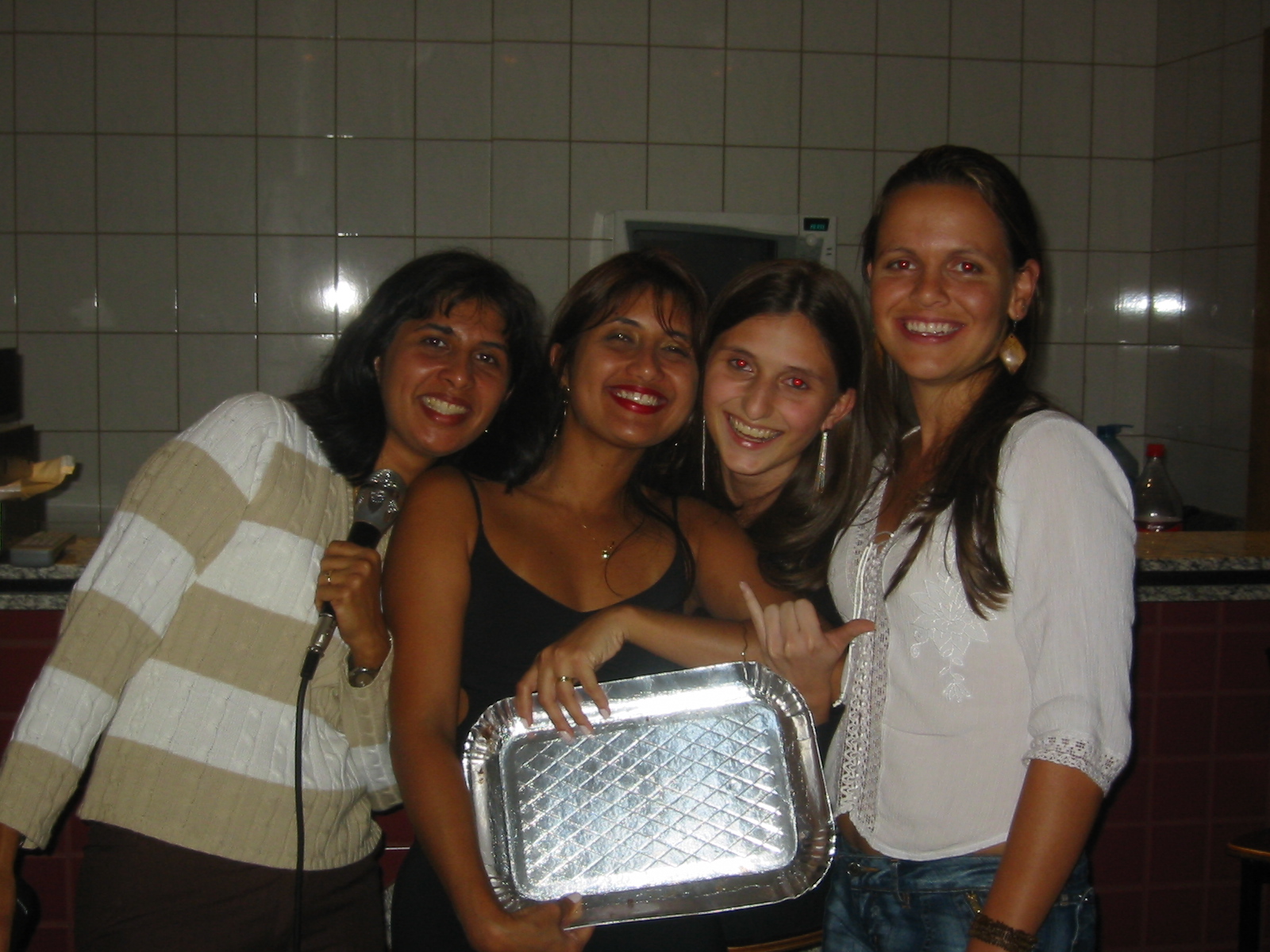 four girls are posing with a metallic tray