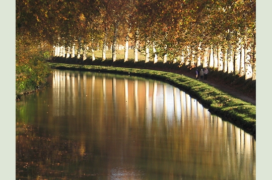 two people sitting on a bench beside water