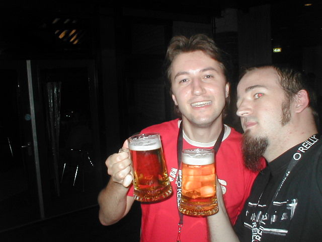 a couple of guys holding up some very big beer glasses