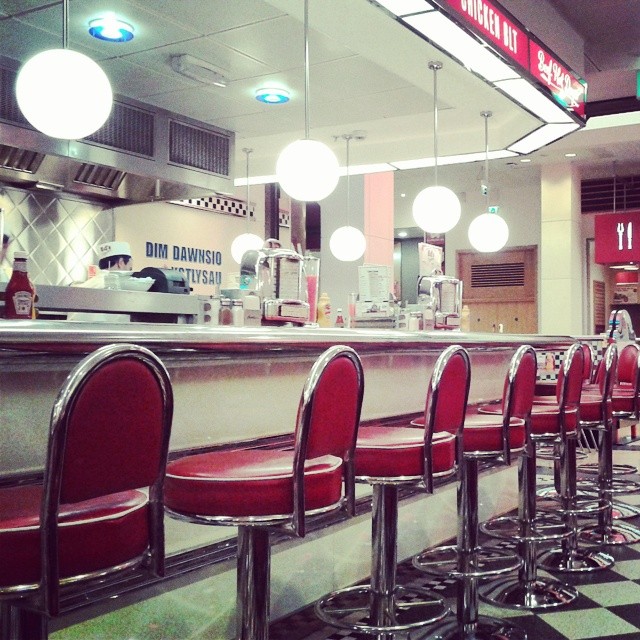 a diner with many red chairs on the front row