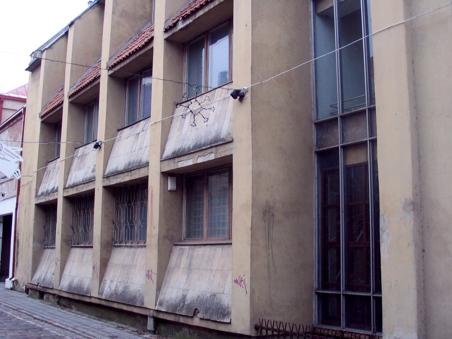 a building with peeling paint and windows on a street