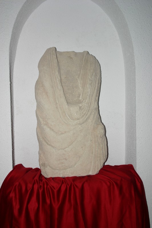 a sculpture on a couch with a red blanket on top