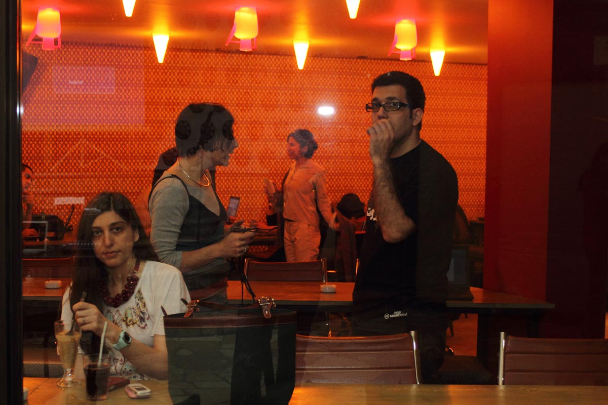 a group of people sit in an orange - walled restaurant