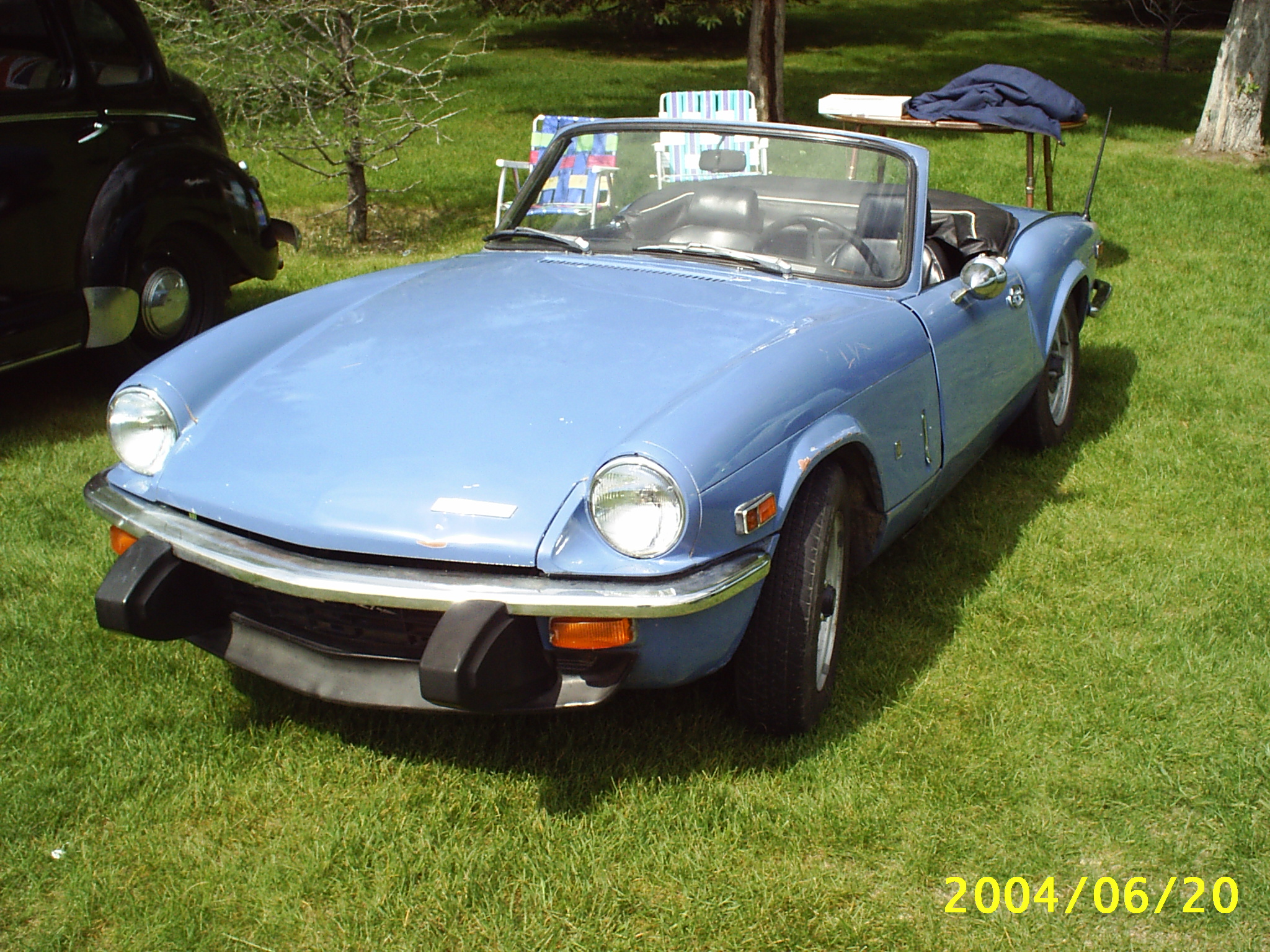 an old blue sports car is on display at an auto show