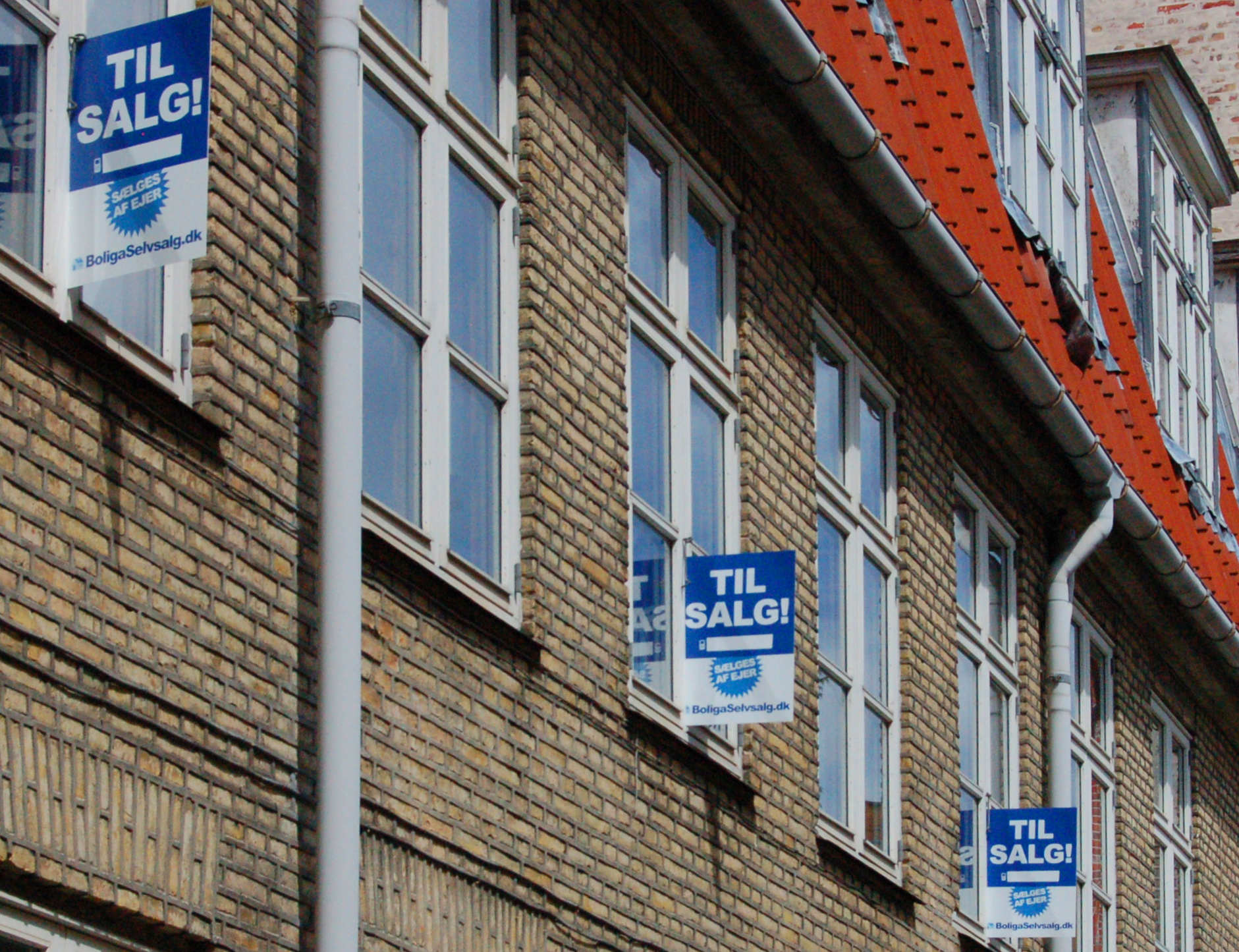 blue signs next to brick buildings with brick roof