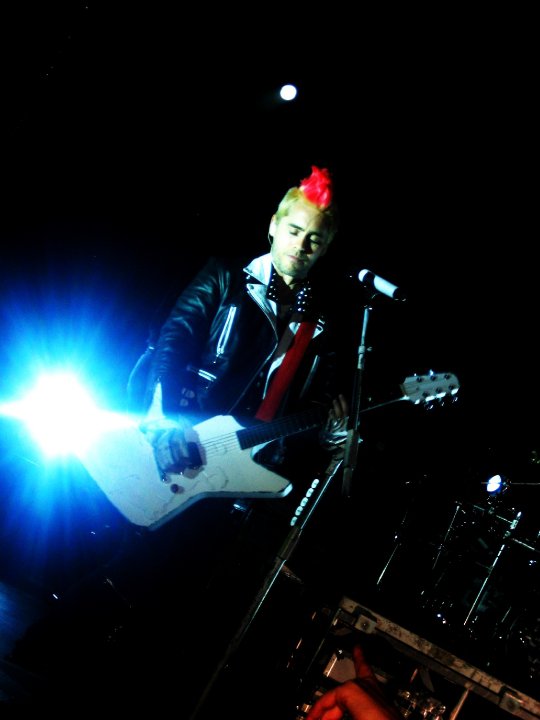 a male with a red hair is playing the guitar