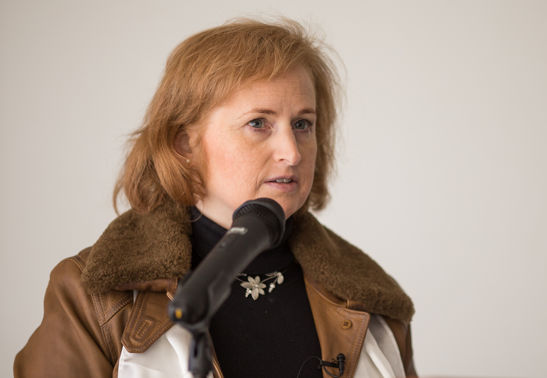 an elegant woman standing at the microphone in front of her