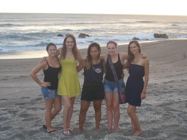 six girls are posing for the camera on a beach